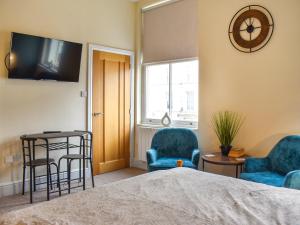 a bedroom with two chairs and a bed and a clock at Denelea Studio 1 - Uk49952 in Scarborough