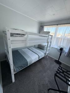 two bunk beds in a room with a window at Homely Gurl in Hamilton