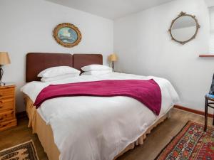 sypialnia z dużym łóżkiem i lustrem w obiekcie Broomstick Cottage w mieście Elsdon
