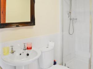 łazienka z umywalką, toaletą i lustrem w obiekcie Broomstick Cottage w mieście Elsdon +10 zdjęć