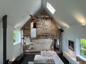 a living room with a white couch and a brick wall at Croft Lodge Studio in Leominster