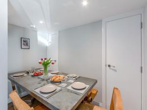 a dining room with a table with plates and flowers at Tower Cottage in Glenridding