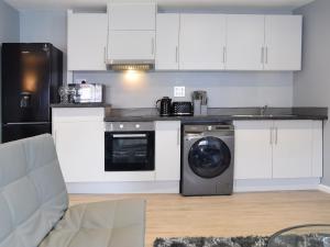 a kitchen with white cabinets and a washing machine at Apartment 4 - Uk50138 in Stoke on Trent