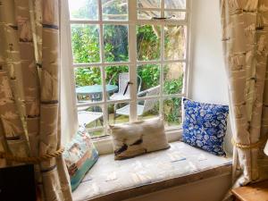 a window seat with a pillow in front of a window at Laurel Cottage in Stoke Gabriel