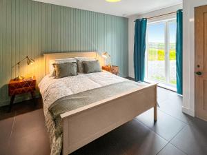 a bedroom with a large bed and a window at Taigh Mullach Dearg in Portree