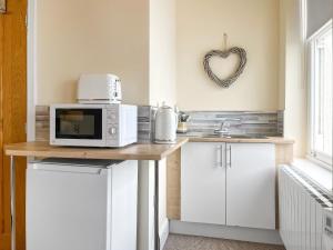 a kitchen with a counter with a microwave on it at Denelea Studio 2 - Uk49953 in Scarborough