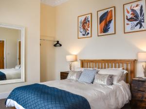 a bedroom with a large bed and a mirror at Denelea Studio 2 - Uk49953 in Scarborough +4 photos