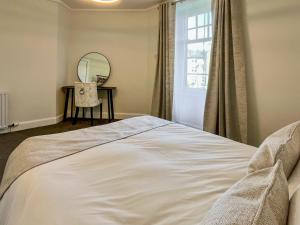 a bedroom with a large white bed and a mirror at Queen Street Apartments 3 in Dundee