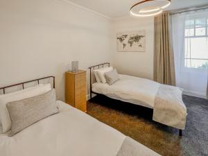 a bedroom with two beds and a window at Queen Street Apartments 3 in Dundee