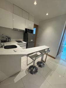 a white kitchen with a sink and a counter at Beachside Bliss in Ban Saiyuan (1) +2 photos