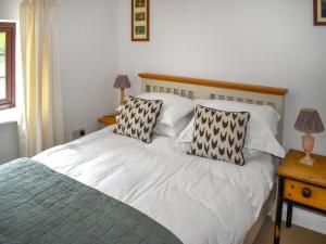 a bedroom with a bed with two pillows on it at Townwood House in Tiverton