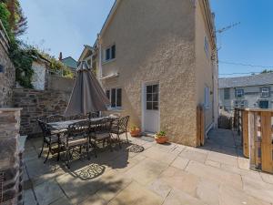 a patio with an umbrella and a table and chairs at Spring Gardens in New Quay