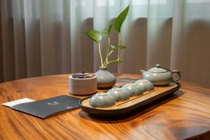 a table with a tray with a plant and a tea pot at 品缦芸酒店长沙高铁南站沙湾公园地铁站店 in Changsha