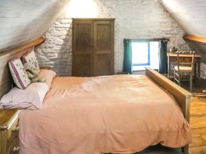 una camera da letto con un letto grande in una mansarda di Thatched Cottage - Uk50261 a Llandeilo Altre 5 foto