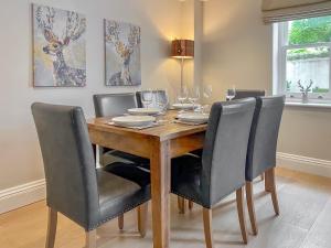 Rye Cottage في هلمسلي: طاولة غرفة الطعام مع الكراسي وكؤوس النبيذ