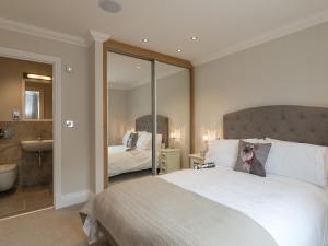 Rye Cottage في هلمسلي: غرفة نوم بها سرير أبيض كبير ومرآة +11 صورة