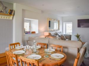 un salon avec une table et un canapé dans l'établissement Tosside Fold Cottage, à Tosside