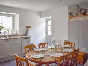 une cuisine avec une table en bois et des chaises ainsi qu'une salle à manger dans l'établissement Tosside Fold Cottage, à Tosside