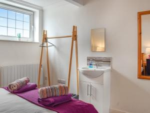 a bedroom with a sink and a bed with purple pillows at Denelea - Uk49954 in Scarborough +13 photos