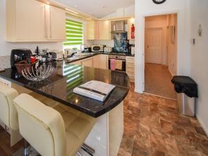 a kitchen with a counter with chairs and a counter top at Sunnybank in Warton