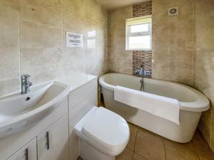 a bathroom with a tub and a toilet and a sink at Ivy - Uk50105 in Brigg
