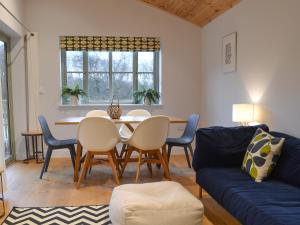 a living room with a table and chairs and a couch at Hen Harrier Lodge-Uc3979 in Saint Columb Major