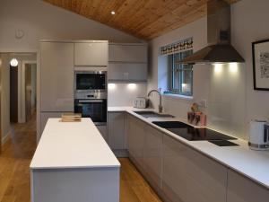 a kitchen with white countertops and a wooden ceiling at Hen Harrier Lodge-Uc3979 in Saint Columb Major