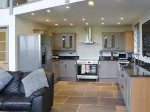 a kitchen with a black leather couch in a kitchen at Heartwell Cottage in Wolsingham +16 photos