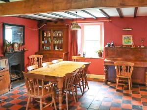 a dining room with a wooden table and a piano at Farm House - Uk50262 in Llandeilo