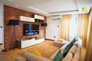 a living room with a couch and a tv at Asa Beach Villa in Trofwi