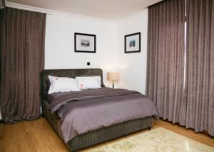 a bedroom with a large bed with curtains at Asa Beach Villa in Trofwi +15 photos