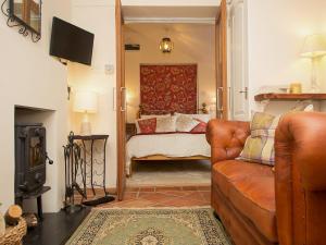 a living room with a couch and a bed at Gamekeeper's Cottage in Staple