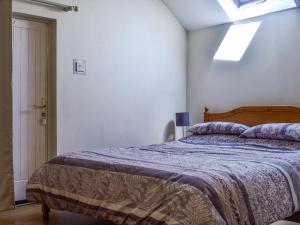 a bedroom with a bed with a blue blanket at The Stable - Uk49829 in Callington +5 photos