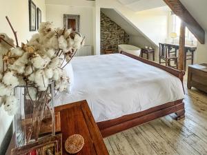 a bedroom with a bed and a vase of flowers on a table at Anran Manor - Uk50366 in Newton Abbot +1 photo