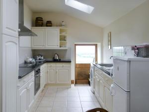 a white kitchen with white appliances and a window at Townhead Mill in Carronbridge
