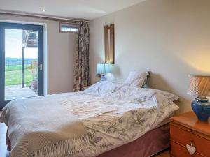 a bedroom with a bed and a window with a view at Townhead Mill in Carronbridge