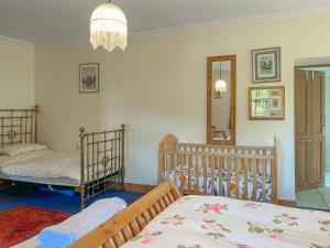 a bedroom with two cribs and a mirror at Townhead Mill in Carronbridge