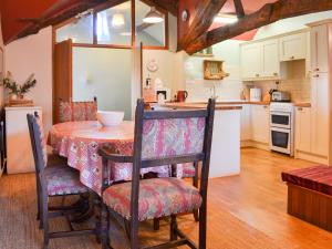 Una cocina y un comedor con mesa y sillas. en Birkerthwaite Cottage-W41479, en Eskdale