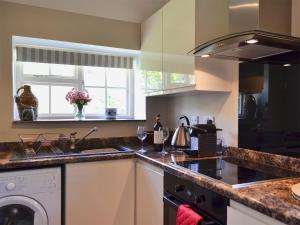 eine Küche mit Spüle und Waschmaschine in der Unterkunft Cowbeech Farm Cottage in Herstmonceux