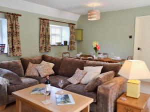 ein Wohnzimmer mit Sofa und Tisch in der Unterkunft Cowbeech Farm Cottage in Herstmonceux