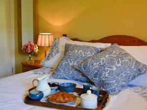 ein Tablett mit Essen auf dem Bett in der Unterkunft Cowbeech Farm Cottage in Herstmonceux + 11 Fotos