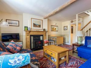 Una sala de estar con un sofá y una chimenea. en September Cottage, en Lechlade