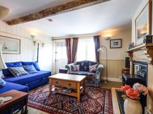 Una sala de estar con un sofá azul y una mesa. en September Cottage, en Lechlade