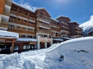 une pile de neige devant un bâtiment dans l'établissement Appartement 2 pièces proche télécabine, 4 personnes, parking gratuit - FR-1-561-145, à Valfréjus