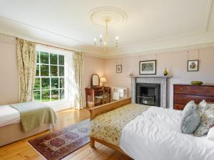 una camera da letto con due letti e un camino di Winton Cottage - Uk50380 a Pencaitland