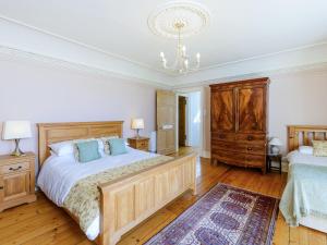ein Schlafzimmer mit einem großen Bett und einem Kronleuchter in der Unterkunft Winton Cottage - Uk50380 in Pencaitland + 18 Fotos