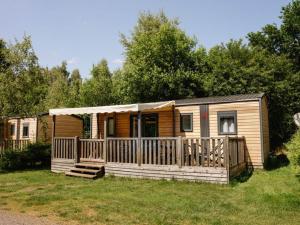 a wooden cabin with a porch and a deck at Mobil home 32m² avec terrasse, 3 chambres pour 6 personnes - API-1-52-713 in Barbey-Séroux