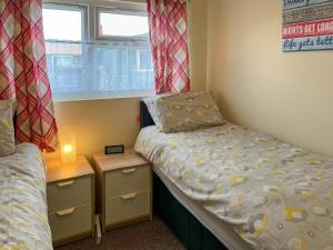 a small bedroom with two beds and a window at Rosie's Cottage in Bridlington