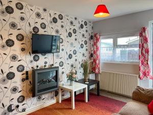 a living room with a flat screen tv on a wall at Rosie's Cottage in Bridlington