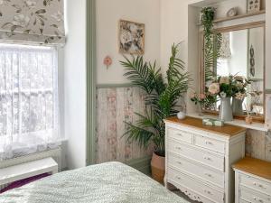 una camera da letto con cassettiera e specchio di Issys Cottage a Helston Altre 13 foto